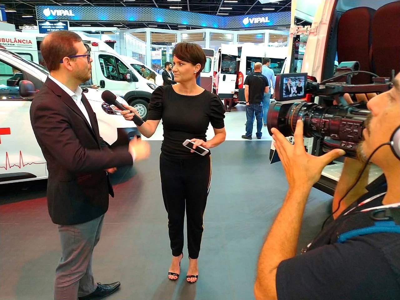 Silvia Garcia entrevistando em feira automotiva