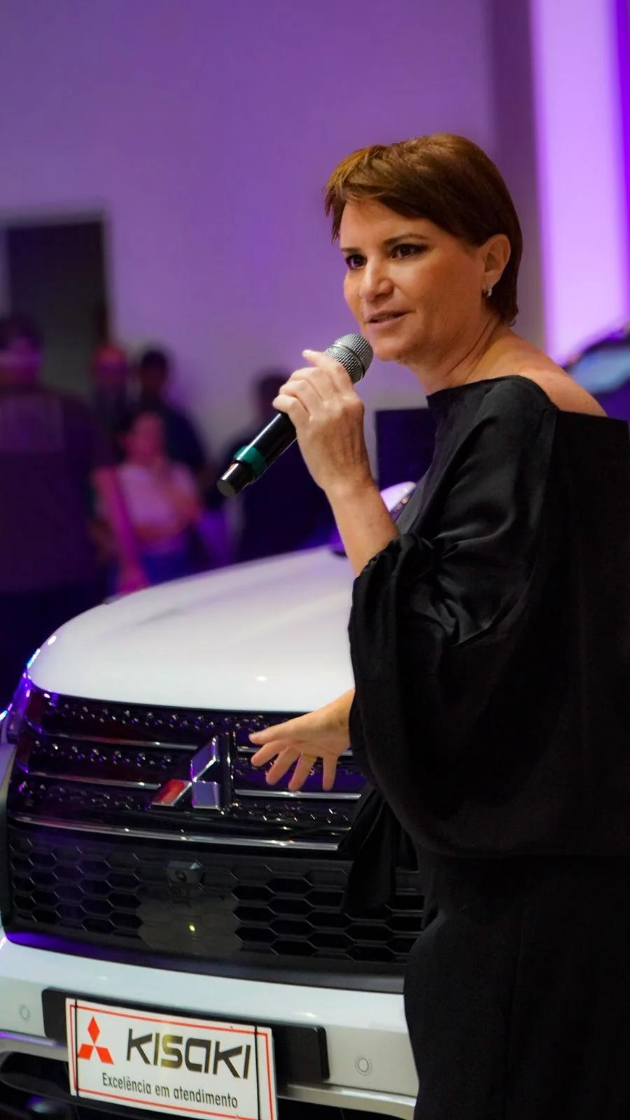 Silvia Garcia apresentando evento automotivo com microfone